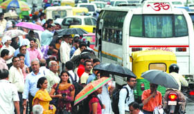 People wait for their bus at the ITO during the heavy traffic jam after the rains in New Delhi on Thursday.
