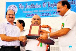 Minister for Industries and Commerce Surjit Singh Salathia gives away the Engineer of the Year Award to PK Nanda at a function in Jammu on Thursday