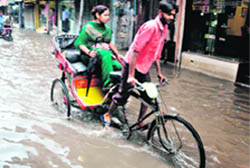 A rickshaw-puller wades through a flooded street near Town Hall road in Ludhiana 
