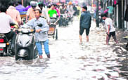 A boy makes his way through a flooded street in the Zone A office of the municipal corporation in Ludhiana.