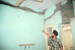 Gagandeep Singh shows cracks on walls in his house, which appeared after the building collapse on Friday.