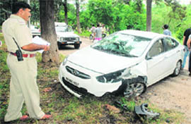 A police official investigates the scene of an accident after a speeding car grazed three trees before coming to a halt near the Government College of Art, Sector 10, in Chandigarh