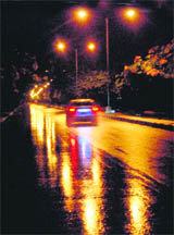 Lights are reflected on a wet stretch of the road separating Sectors 33 and 34 in Chandigarh