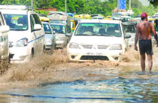 Vehicles wade through a waterlogged road near the Indira Gandhi Stadium in New Delhi on Friday