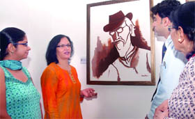 Artist Sandhya Singh explains her painting 'The Magician' at her exhibition 'Remembering the Master - M.F. Husain' in New Delhi on Friday. 