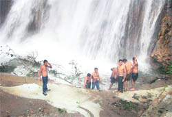 Tourists exposed to risk near the damaged area of the main swimming pool at the Kempty Falls, near Mussoorie.