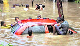 A car submerged in a flooded locality after a downpour in Faridabad on Friday