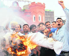 BJYM activists burn an effigy of the UPA Government over petrol price hike in Amritsar on Friday. 