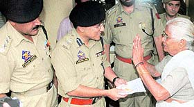Anand Jain, SSP, Jammu, returns stolen cash and gold items to their owner in Jammu on Friday.