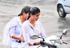 Schoolgirls caught in rain on their way back home in Jammu. 