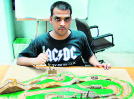 Vineet Sharma with a model of a mountain biking track