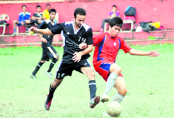 Players of Carman School, Shyampur (in red), and Carman School, Dalanwala, struggle to get the ball in a match in the Ram Bahadur Chhetri football tournament in Dehradun on Saturday