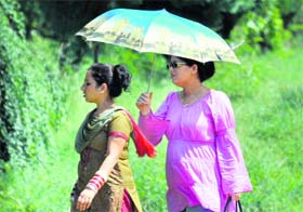 Two women with an umbrella at the University of Jammu on Saturday. 