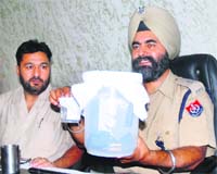 A police officer shows the arms seized from the accused in Jalandhar on Saturday.