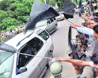 Students of the Gauhati varsity show black flags to CM Tarun Gogoi on his arrival from Delhi. 