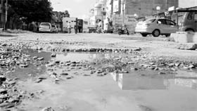 A damaged road on the rear of the market at Phase XI in Mohali.