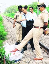 A cop from the Haryana police examines bodies of a couple with foot on the Chandigarh-Delhi railway tracks near Sector 9, Panchkula, on Sunday.