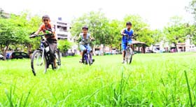 Children cycle in a park as the grass has not been mowed in Sector 32, Chandigarh on Wednesday.