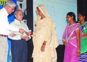 Praveen Kumar Tripathi, chief secretary of the Delhi government gives papers for SBI banking facilities to the underprivileged in New Delhi on Sunday