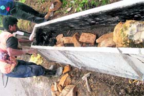 A labourer fills a concrete barrier with substandard material on the Mussoorie-Kempty road.