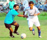 Players of Wills Youth Club (in white) and Doon Star Club (in blue) in action in a match of the Doon Collisto Cup Tournament in Dehradun on Sunday.