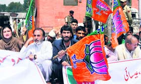 BJP activists hold banners and flags during their three-day fast in Srinagar on Sunday.