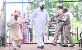 A man helps an elderly woman to a polling booth