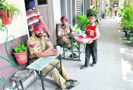 Despite a ban on child labour, a child serves refreshments to cops