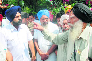 SGPC candidate Jathedar Roop Singh (Independent) argues with a SAD worker over alleged booth capturing at Buttar Shreen in Muktsar. 
