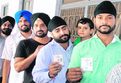 Patit Sikhs with their beards trimmed queue up to cast their vote in Jalandhar, despite the Gurdwara Election Commission orders. 