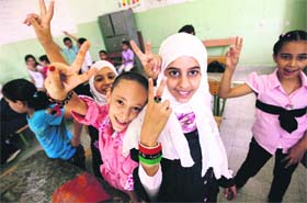 Libyan students flash victory sign at the start of the school year in Tripoli on Sunday as schools in the capital are replacing repeated oaths of allegiance to Gaddafi with lessons in democracy