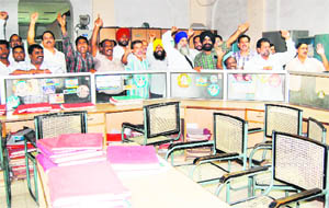 Permanent staff members of the Municipal Corporation protest against deputation of Class IV-level employees on their position in Amritsar on Monday.