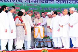 Chiranji Lal Sharma flanked by Chief Minister Bhupinder Singh Hooda and Governor Jagannath Pahadia cuts the cake in Rewari.