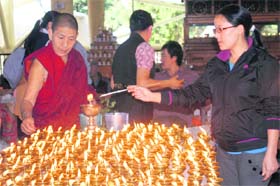 Tibetans light lamps at the Dalai Lama temple at McLeodganj in Dharamsala on Monday.