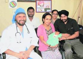 Gurbax Kaur with her husband Manmeet Singh and their baby pose with the doctor at the CMCH in Ludhiana on Monday