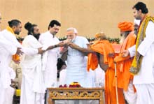 Gujarat CM Narendra Modi (C) drinks lemon water offered by various religious leaders to break his fast in Ahmedabad on Monday.