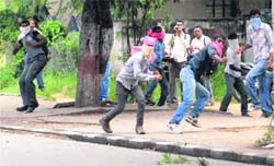 Osmania University students hurl stones at policemen in Hyderabad on Monday. 