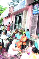 Residents of Ram Nagar assemble outside an old Shani temple in Karnal to prevent the administration from demolishing the shrine on Tuesday. 