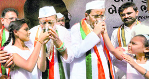 Congress leaders Shankersinh Vaghela and Arjun Modhwadia break their fast in Ahmedabad on Tuesday. 