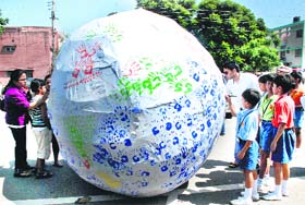 Students and people write messages on a 12-feet dummy earth during a signature campaign organised by Dikshant Global School to observe the International Peace Day in Panchkula on Wednesday