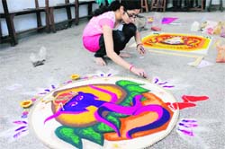A girl participates in rangoli making competition at Government College for Women.