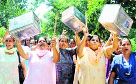 Members of the Anganwari Mulazam Union Punjab beat cannisters in support