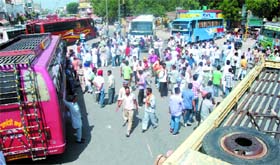 While the transporters held up traffic near the bus stand following protests against each other on Thursday.