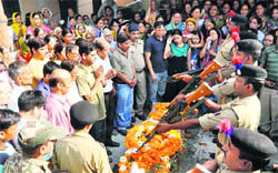 Two daughters of martyr Ram Chander Singh Rana salute as personnel of the BSF reverse arms near the body in Dehradun