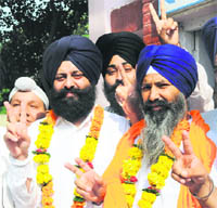 Bhupinder Singh(right) displays the victory sign after being declared the winner from the Karnal seat in the SGPC elections