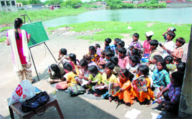 Students attend a class at the government primary school in Dhobiana Basti. Fly ash dumped here is proving to be a health hazard for the students. 