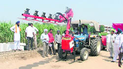 Farmers have a look at an imported pruning machine during the Kisan Mela at PAU in Ludhiana