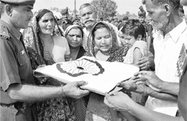 Army personnel present the Tricolour to the family of soldier Jitendra, who died in Sundays earthquake in Sikkim, after his cremation in his native village Maura Milak in Moradabad district. 