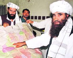 Jalaluddin Haqqani (right), the Taliban's Minister for Tribal Affairs, points to a map of Afghanistan in Islamabad in this October 19, 2001, photograph