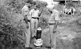 Policemen inspect the site where the bag was found.